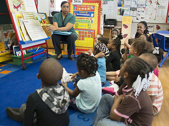 Children in class listening to a teacher