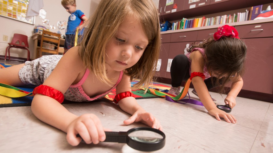 Claire Hedgepeth uses a magnifying glass to investigate along with others in a pre-K class at Myrtle Grove Baptist Church Pre-School Learning Center