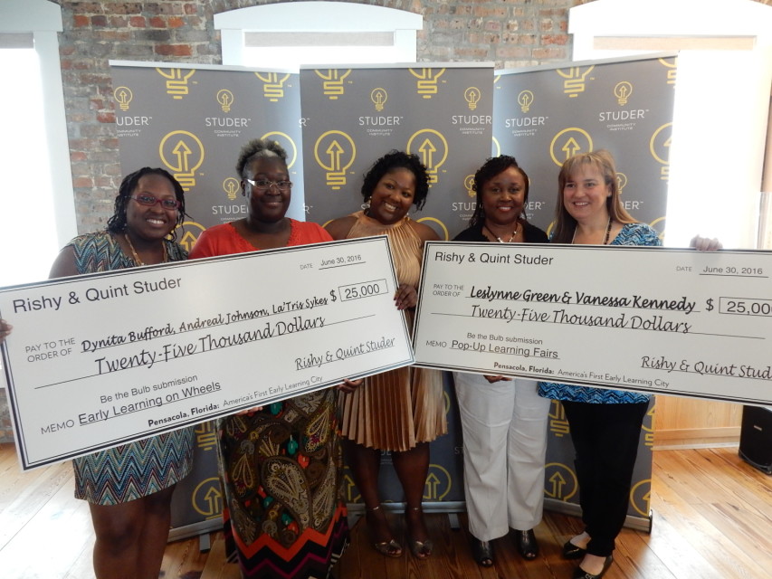 Five women holding two large checks for $25,000 each