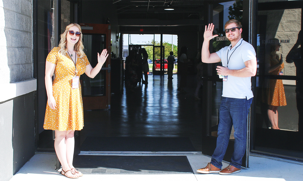 Two employees welcoming you into the building being brand ambassadors.