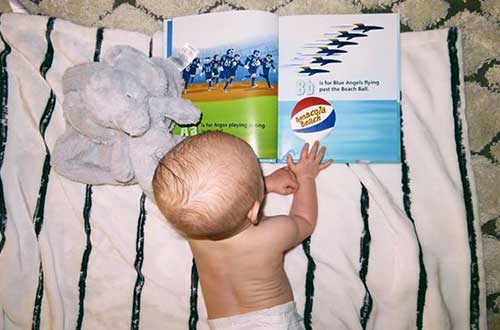infant looking at picture book